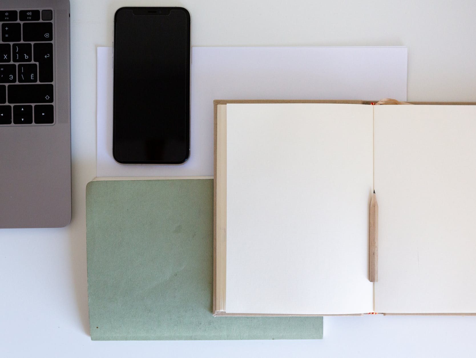 Photo of computer, book, pencil, and phone on desk by Tatiana Syrikova on Pexels.com